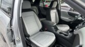 Open car door reveals gray upholstered front and back seats with a quilted pattern and center console visible inside the SUV