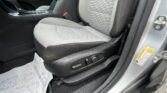 Front passenger seat and center console of a car interior, with seat belt buckle visible and floor mat underneath.