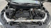 Front view of an engine bay with Ecotec cover and exposed components under the hood of a car.