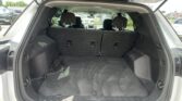Open SUV trunk with folded rear seats and a coiled rope on the floor in the cargo area.