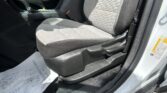Inside a car showing the front passenger seat, center console, and seat belt buckle with a paper floor mat nearby