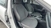 Open car door exposing the car's black fabric front seats, center console, and steering wheel on the right side inside a modern sedan.