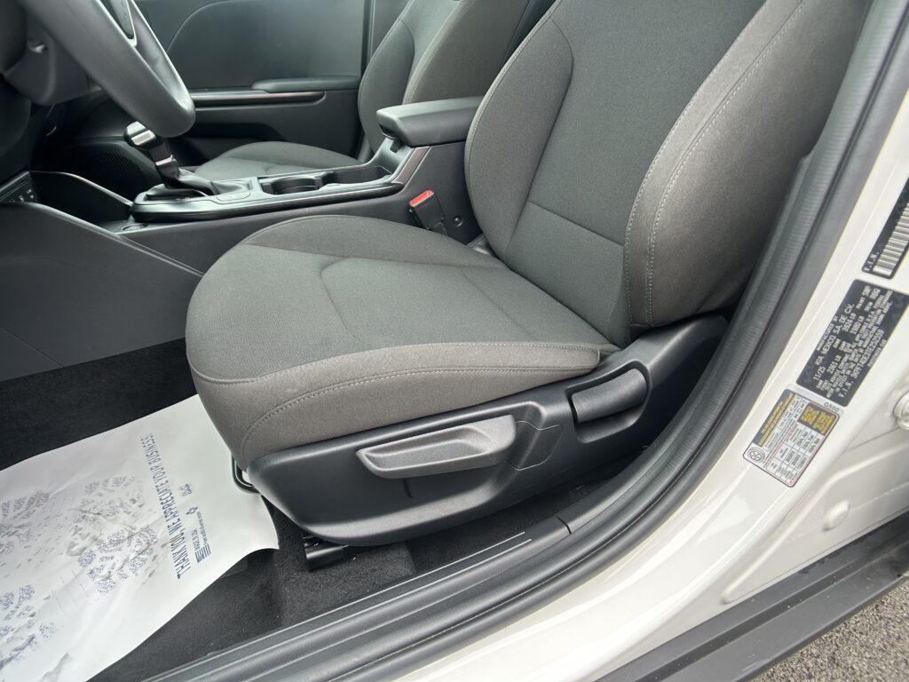 Interior of a car showing the front seats, center console, and gear shifter in dark fabric upholstery.