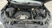 Open car hood showing engine bay with battery, air intake, and fluid reservoirs visible in a sedan's front compartment