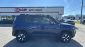 Blue SUV parked in front of E-Z Loan Auto Sales on a sunny day.