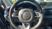 Close-up view of a Jeep steering wheel inside a car, with the dashboard and exterior traffic visible through the windshield