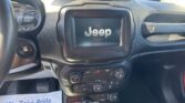 Center infotainment screen showing a 3D Jeep logo; car dashboard and steering wheel visible around it.