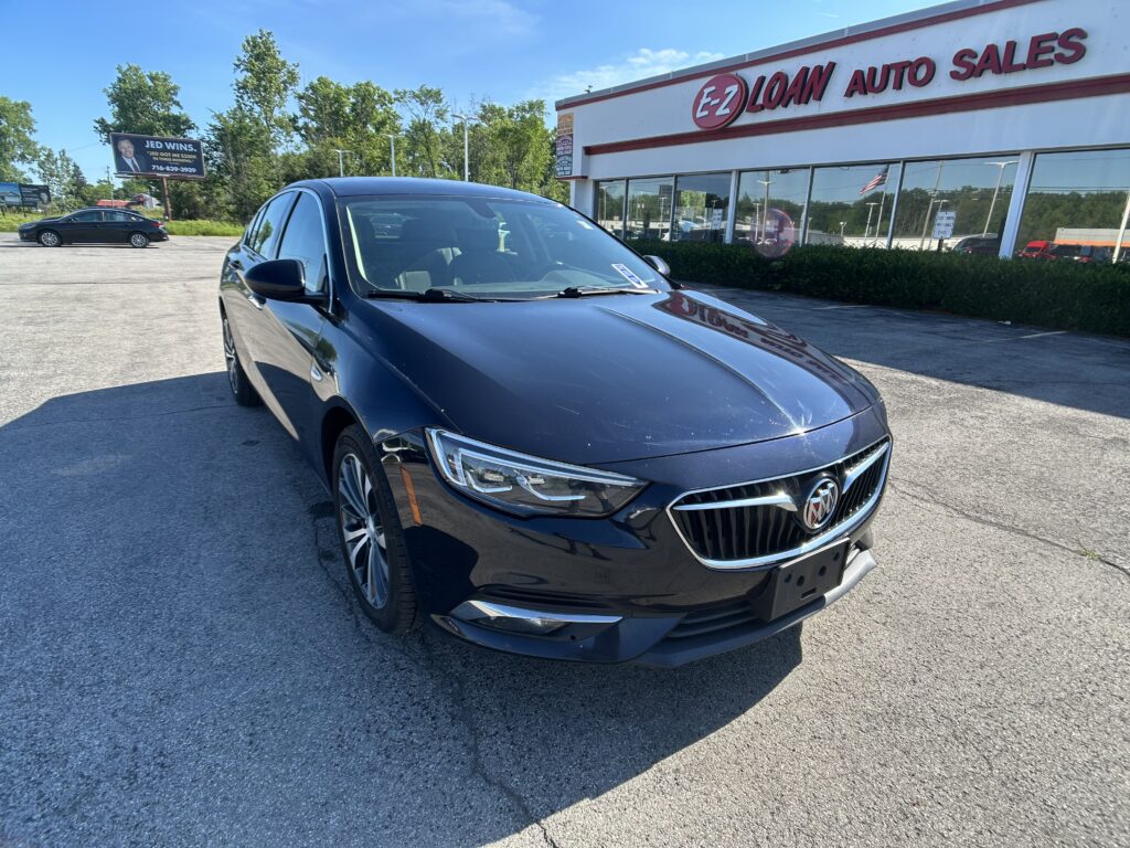 Front-left view of a dark blue Buick sedan parked in a car lot outside EZ Loan Auto Sales.