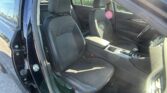 Front and passenger seats in a dark car, driver’s door open and exterior visible outside edge of the photo.