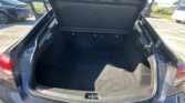 Open SUV trunk showing spacious cargo area with rear seats upright and tailgate raised in a parking lot