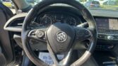 Driver's perspective showing the steering wheel, instrument cluster, and an in-car touchscreen/map display.