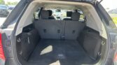 Open SUV rear hatch revealing spacious cargo area with third-row seats upright and visible dashboard in the background.
