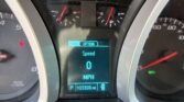 Car dashboard with digital speed readout showing 0 and the word 'Speed'; center display indicates 'Trip' and 'Option' with odometer reading 103,308 miles; includes tachometer and fuel gauge nearby.