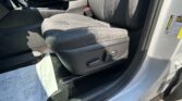 Car interior: front seats, center console, gear shifter, and a document resting on the passenger-side floor mat.