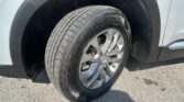 Close-up of a car tire mounted on a silver alloy wheel, with the gray SUV fender in the frame.