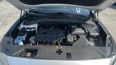 Open car hood showing engine bay and windshield in a parking lot area