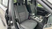 Inside view of a vehicle's front seats and center console, black fabric upholstery with red stitching in a modern SUV. Laptop-like environment not shown; indicates a clean, orderly interior.