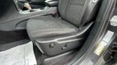 Front interior of a car showing the front passenger seat, center console with gear shifter, and seat belt latch near the door.