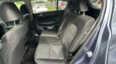 Rear passenger seating in a dark fabric car interior, with three headrests visible in the back row.