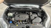 Car with its hood open, displaying the engine bay and front windshield wipers under cloudy light.