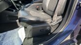 Front interior of a car showing black leather seats, center console, and gear shifter with a red seatbelt buckle visible near the seat.