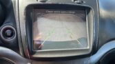 In-car rearview camera display showing parking guidelines and the message 'Check entire surroundings' for safe backing up.