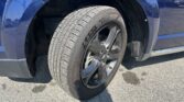 Close-up of a blue SUV front wheel with a Goodyear tire and alloy rim visible in the wheel well of the vehicle.