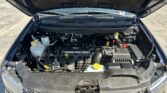 Front view of an open car hood showing the engine bay, with coolant reservoir, battery, and various hoses visible.