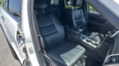 Open rear passenger door reveals black leather SUV interior with front and rear seats, center console, and cupholders visible.