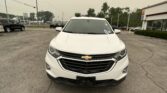 Front view of a white Chevrolet SUV parked in a car dealership lot with other vehicles in the background