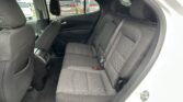 Rear passenger seats in a car: black fabric upholstery with orange stitching, visible headrests and seat belts.