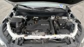 Open car hood reveals the engine bay with an ECOTEC engine cover, battery, and surrounding components visible at the front of the car.