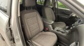 Interior view of a car showing the front seats with gray fabric upholstery and orange stitching, center console, and partially visible dashboard and doors.