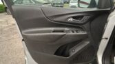 Interior of a car door panel with window controls and chrome handle; parking lot visible outside through the open window.