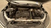 Open car hood view showing engine bay with ECOTEC cover, battery, and wiring