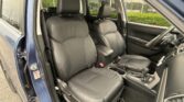 Interior of a blue SUV showing black leather front seats with white stitching and center console between them.