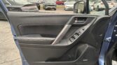 Open blue car door showing the door panel and window/lock controls, with a busy parking lot of SUVs and cars in the background.