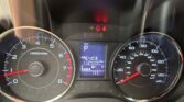 Close-up of a car instrument cluster showing the left tachometer, right speedometer, and a central digital display with mileage and warning icons.