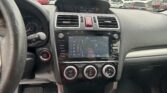 Dashboard of a car interior with a central touchscreen, two air vents, and a red hazard button, viewed from the driver's seat.