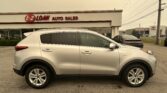 White SUV parked at an auto sales lot in front of a building with an E-Z LOAN AUTO SALES sign