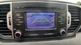 Car dashboard display showing a rearview camera view with yellow guide lines for parking