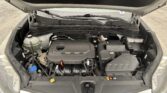 Open car hood exposing engine bay with battery, coolant reservoir, hoses, and windshield wipers visible.
