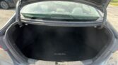 Open trunk of a gray Hyundai Elantra showing a spacious, black-carpeted cargo area with the Elantra name on the floor mat