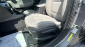 Interior of a gray car showing the front seats, gear shifter, center console, and a printed document on the driver’s side floor area.