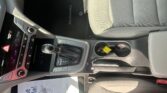 Interior of a car showing the center console with gear shifter, cup holders, and front passenger seat.