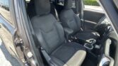 Front and back seats in a dark fabric car interior, driver’s seat on the left and passenger seat on the right, center console visible in foreground.