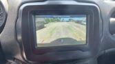 Car's rearview camera screen displaying a parking lot with guiding lines and the message 'Check entire surroundings'