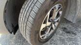 Close-up of a car tire and alloy wheel, showing the tread pattern and wheel well.