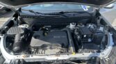 Open car hood revealing the engine bay with an Ecotec engine and various hoses and reservoirs visible behind the windshield