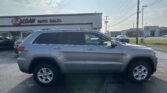 Silver SUV parked in a dealership lot with 'E-Z LOAN AUTO SALES' sign on the building in the background.